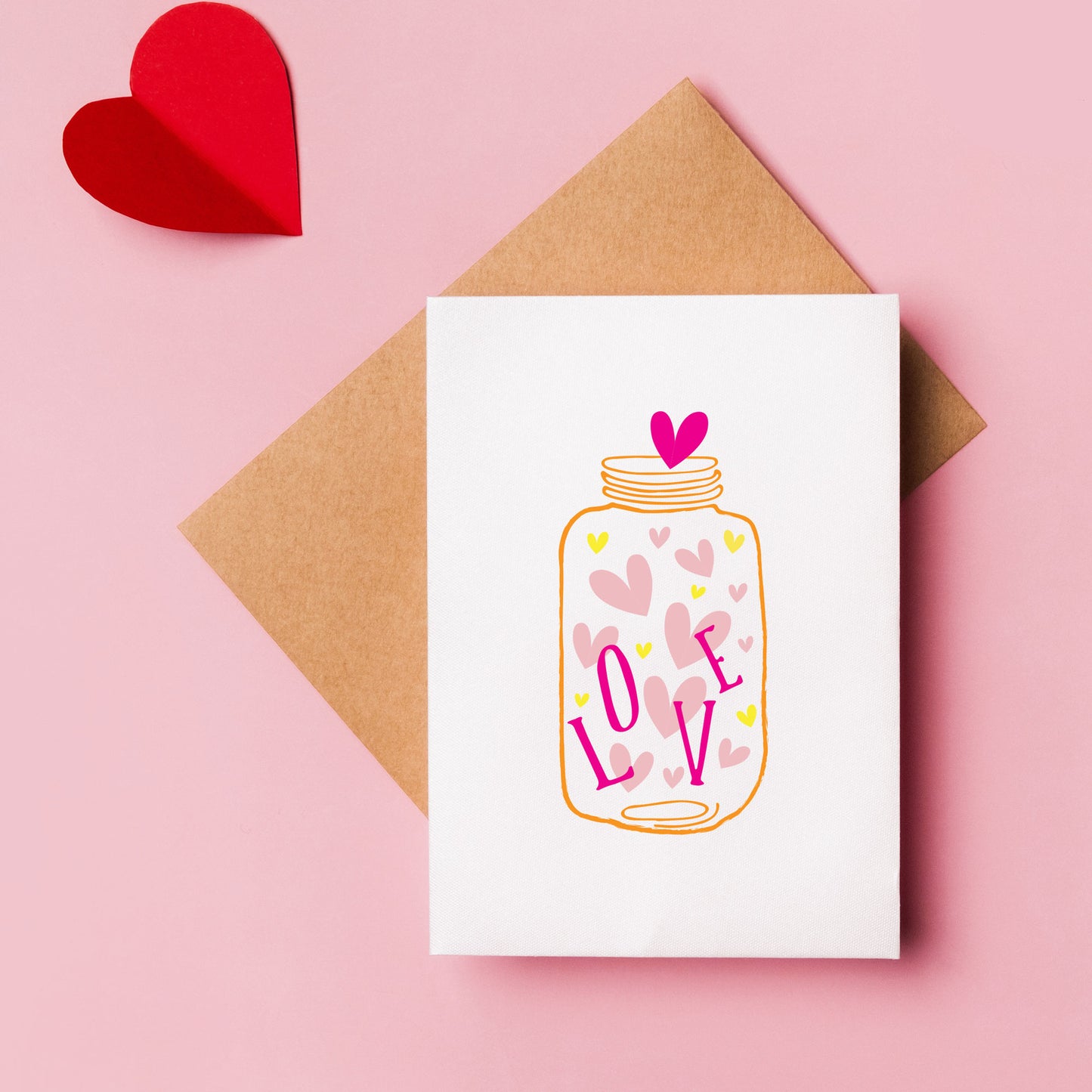 Jar full of love hearts a6 card with kraft envelope on a pink background