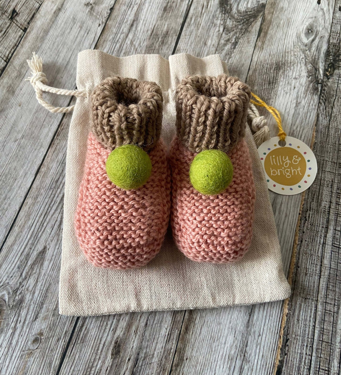 Hand knit Pink Baby Booties by Lilly and Bright with green pom pom wit drawstring bag