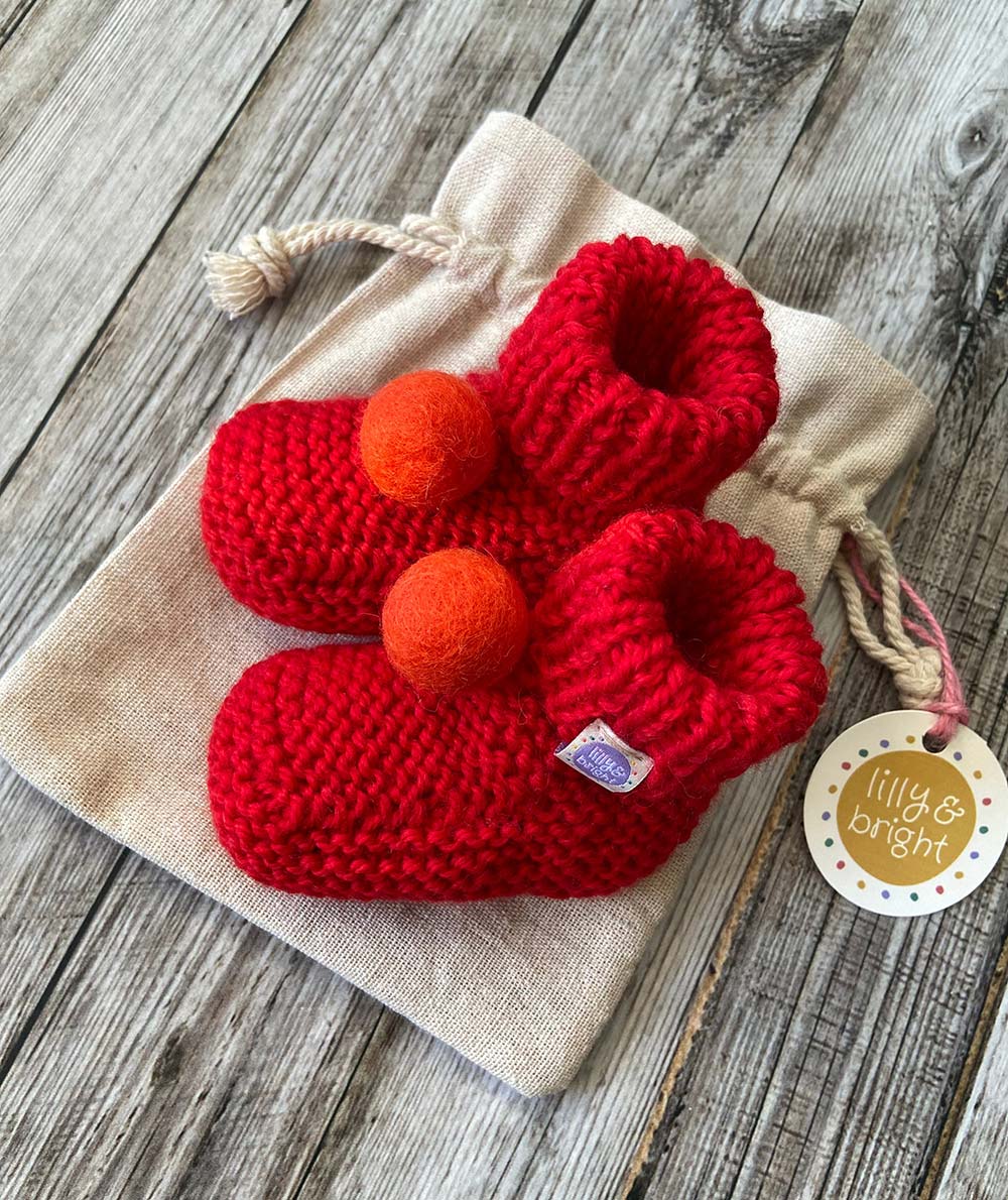 Hand knit Red Baby Booties by Lilly and Bright with pom pom - side view