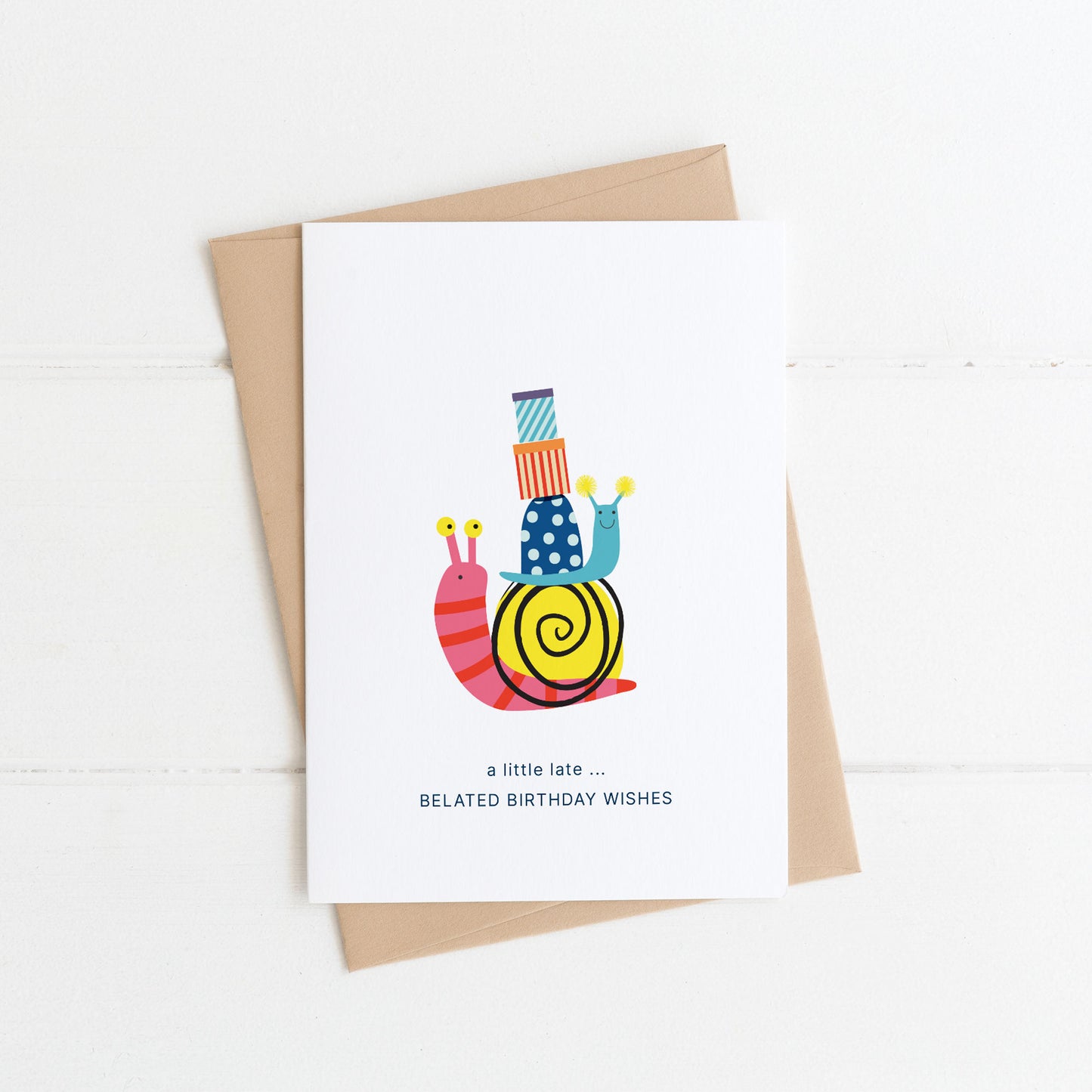 A6 belated Birthday card with two snails carrying birthday gifts.On a wwhite background with a kraft envelope.