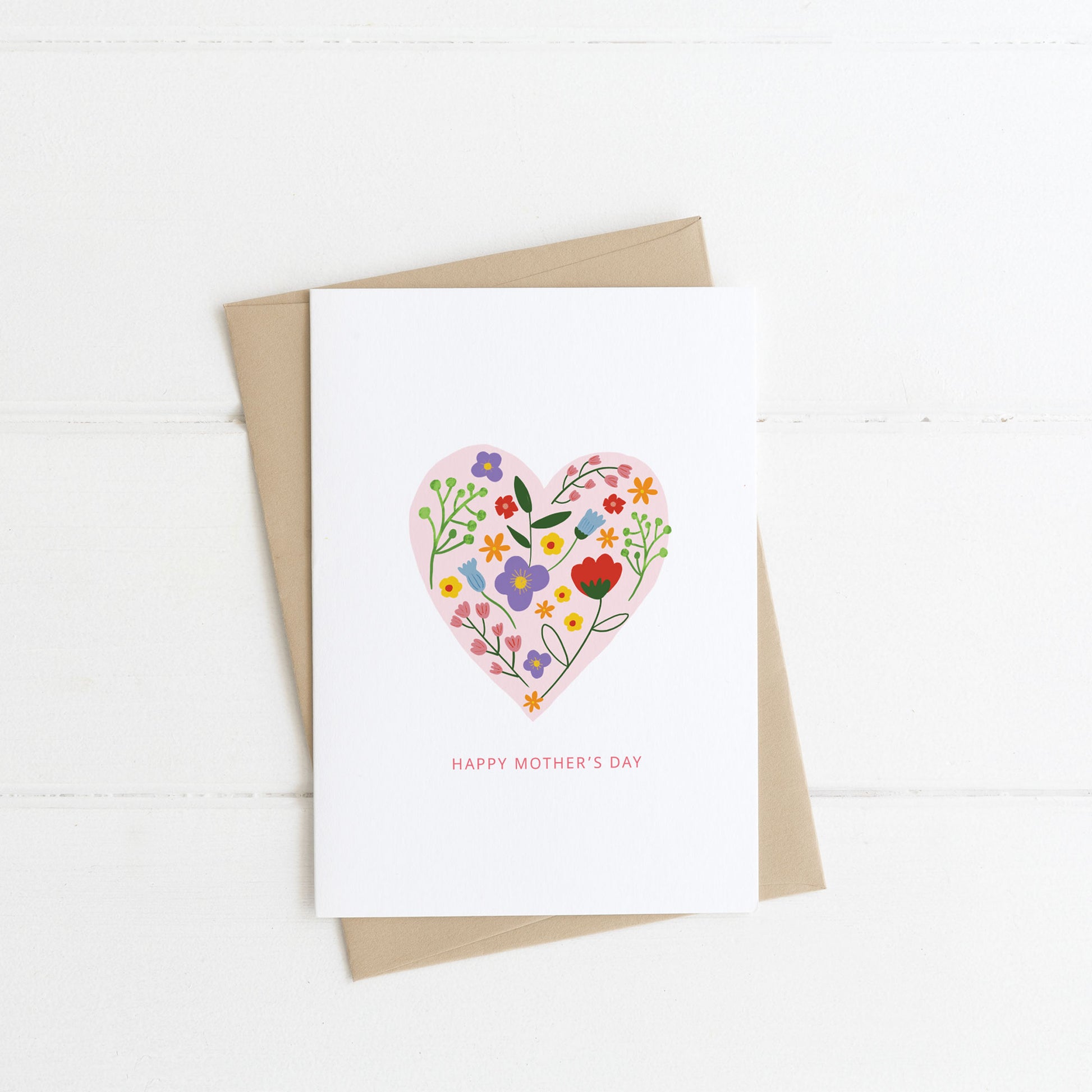 Mother's Day Greeting Card with a Heart full of spring flowers  with a kraft envelope and on a white background